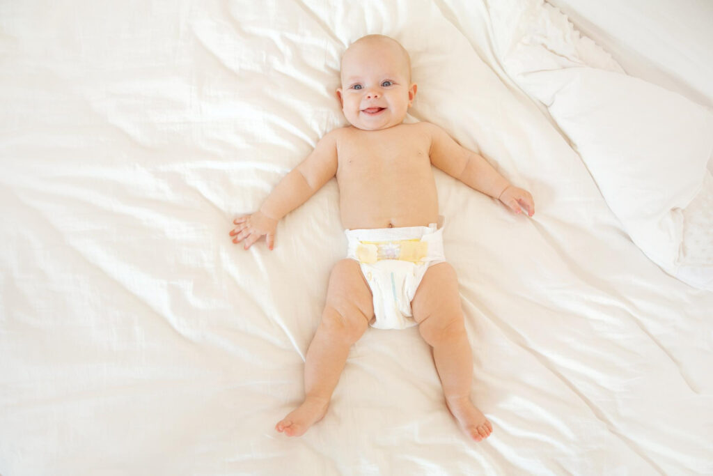 תינוק עם חיתול על מיטה גדולה